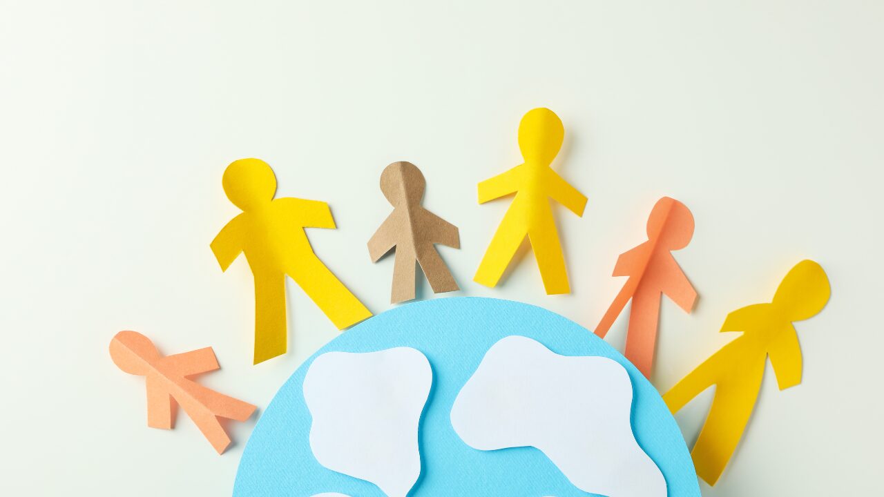 Colorful paper figures surround a globe, symbolizing the growing population's impact on Australia's housing and property market.