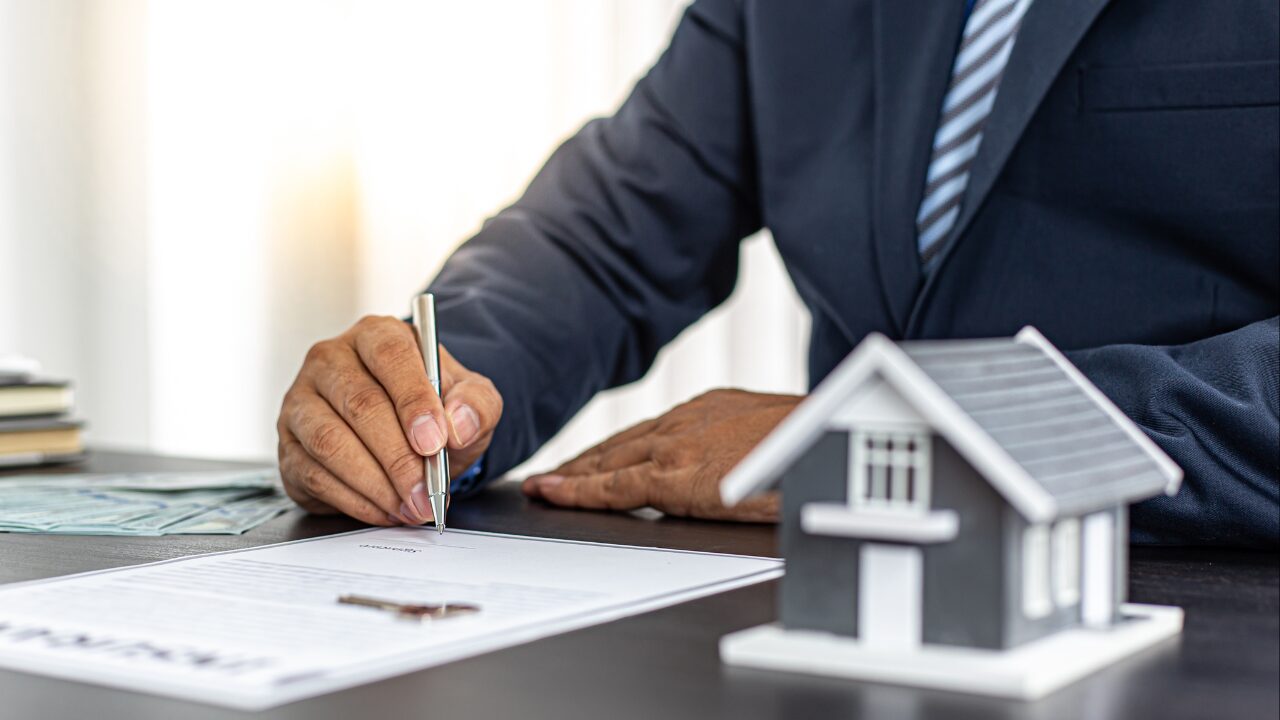 Signing important mortgage documents to explore refinancing options with Yellow Brick Road Home Loans.