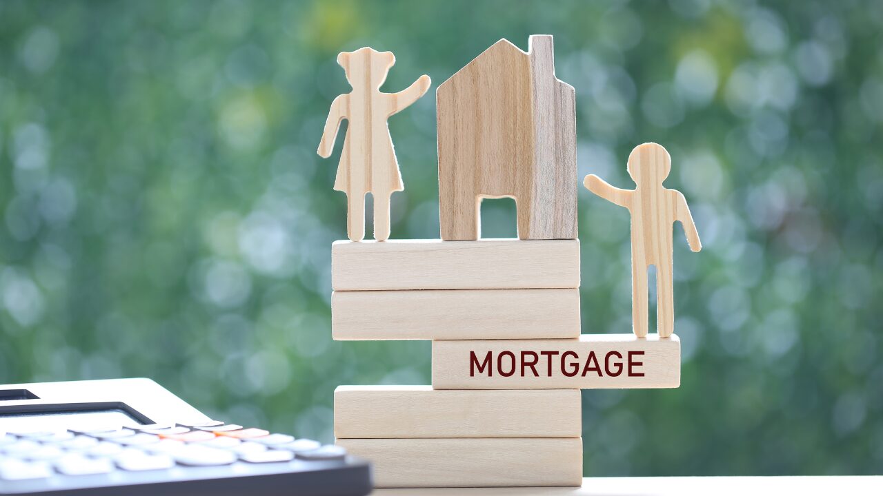 Wooden figures and blocks symbolize refinancing options available through Yellow Brick Road Home Loans.